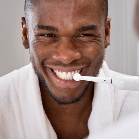 Man using the wisdom power plus pro clean toothbrush